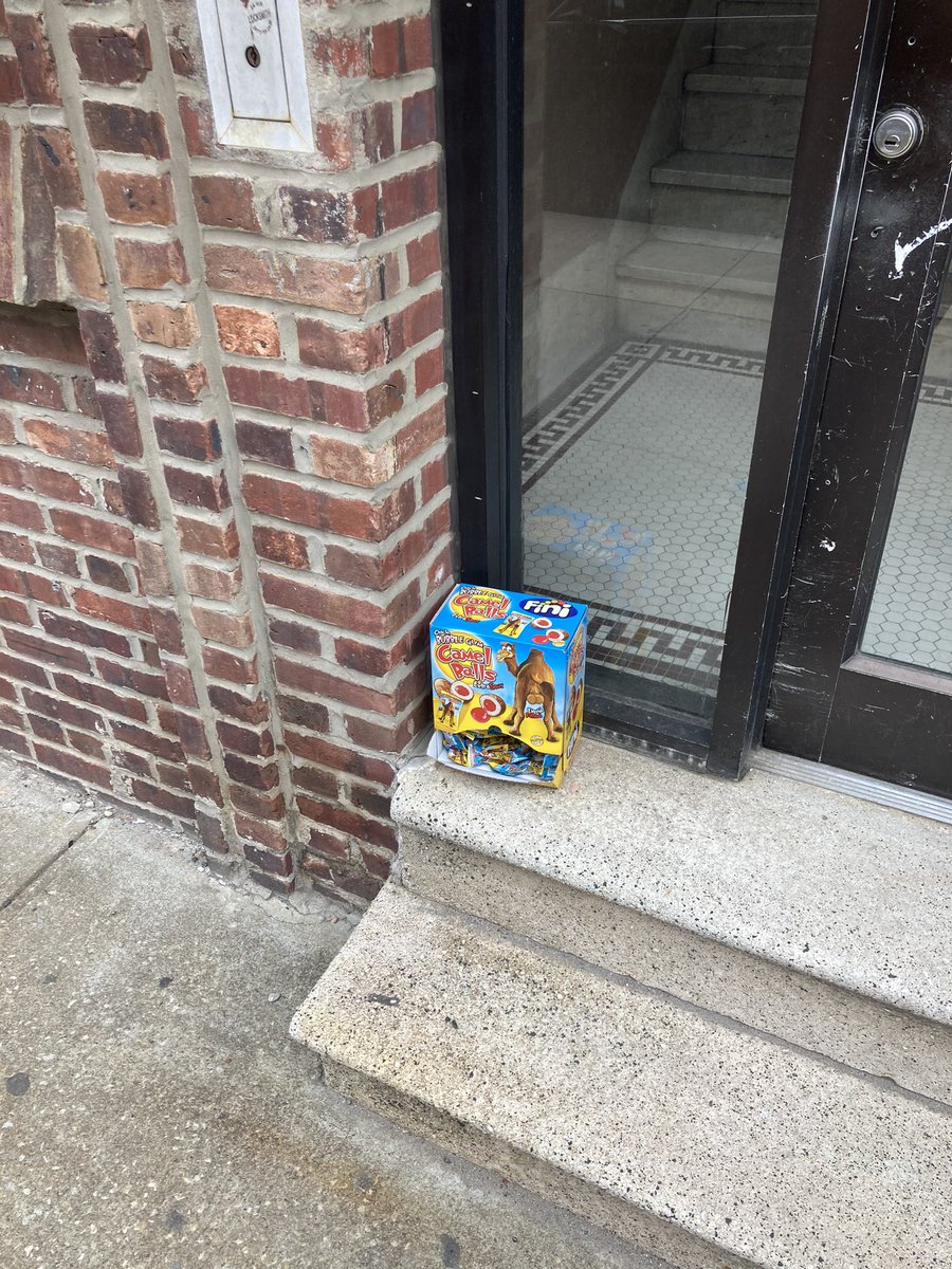 a box of “bubble gum camel balls” on a stoop