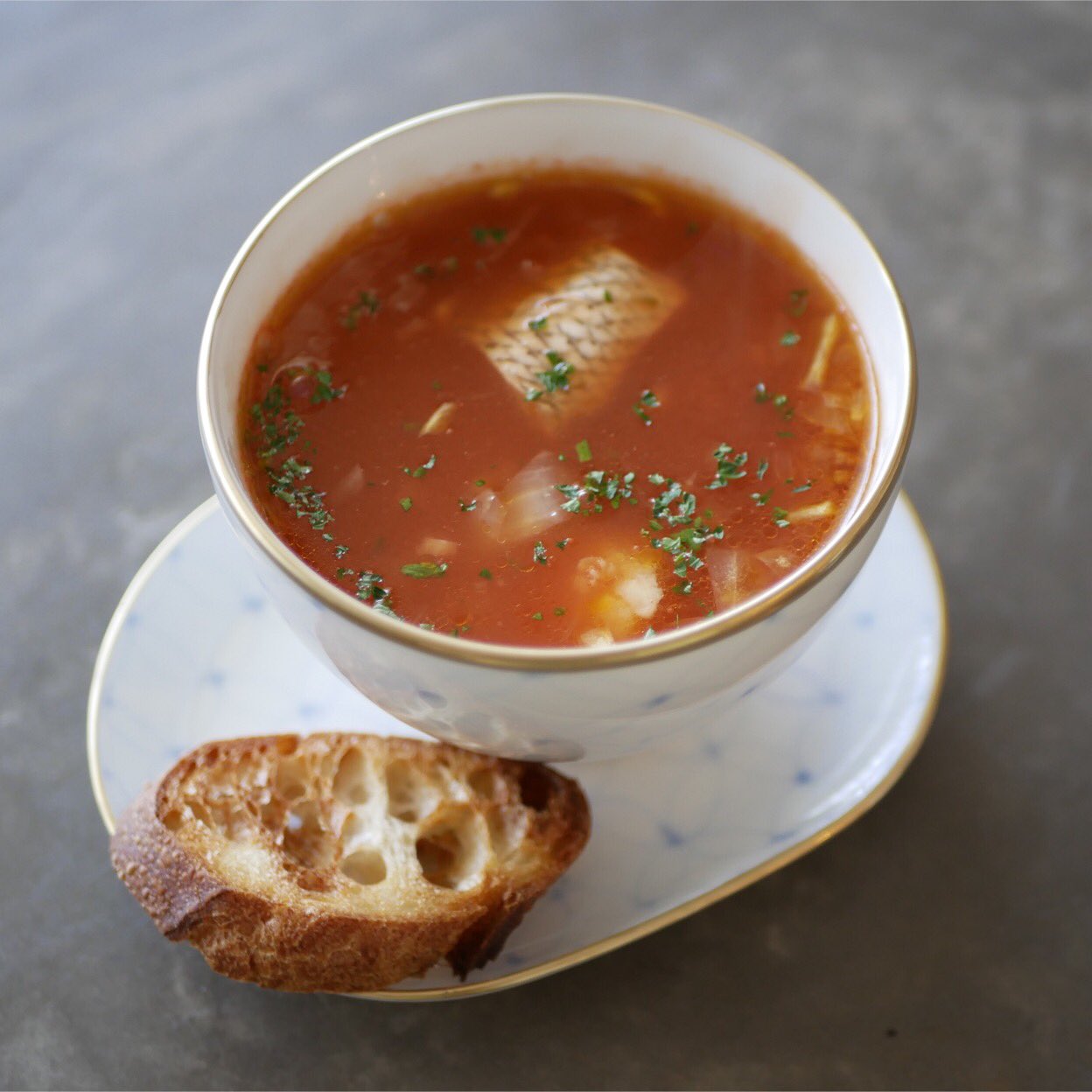 有賀 薫 スープ ド ポワソン 鯛のアラのスープです 特売の切り身に ラッキーなことにアラがついてました 一切れ残った切り身と合わせ トマトジュースと水を加えて煮ます 危うくなりかけのたまねぎやにんにく バジルなども足したら 朝からうちが