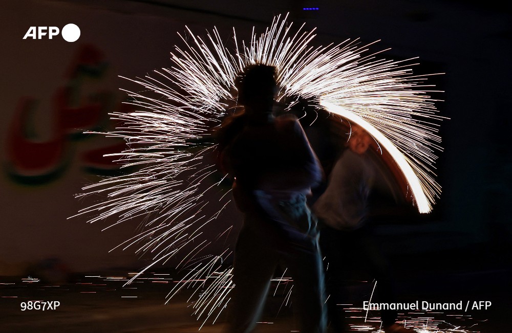 afpfr's tweet photo. Des enfants palestiniens jouent dans les rues de #Gaza après l'iftar pendant le #ramadan @AFPphoto #jeudiphoto #AFP https://t.co/hphKF8UPjh