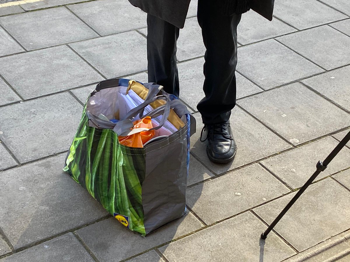 Piers Corbyn, carrying a Lidl bag full of documents, has entered court. He's alleged to have taken part in an illegal gathering on College Green last November