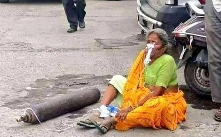Woman in the middle of the Indian street with an oxygen tank giving her breaths of life.