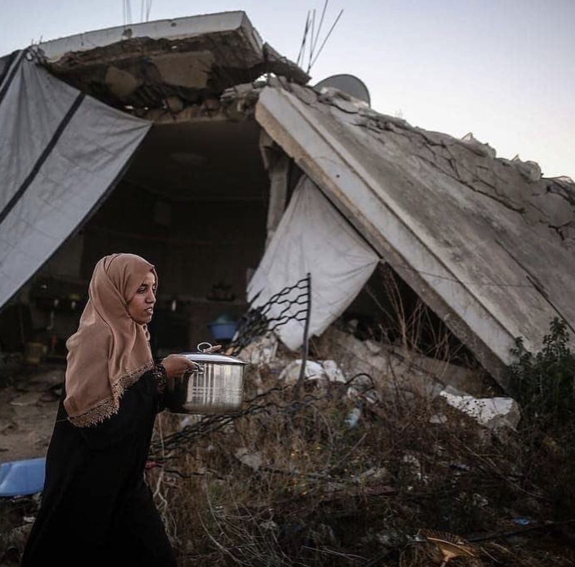 A family in Gaza breaking their fast in their home destroyed by warplanes