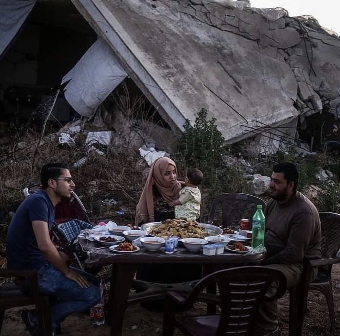 A family in Gaza breaking their fast in their home destroyed by warplanes