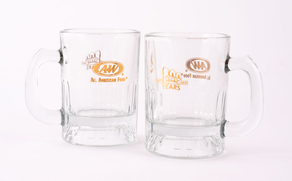 Two gold 100th Anniversary Baby Mugs.