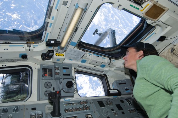 Astronaut Megan McArthur, STS-125 mission specialist, looks through an overhead window on the aft flight deck of Space Shuttle Atlantis during flight day six activities (16 May 2009). 