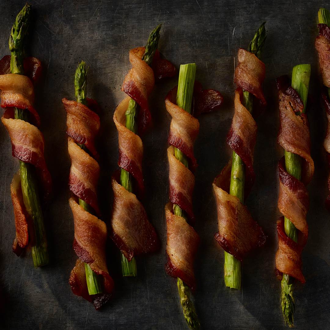 Whether you're hosting a dinner party, or just seeking a delectable side dish, our Bacon-Wrapped Asparagus is a versatile treat that compliments any menu. #dinner #bacon #sidedish #asparagus