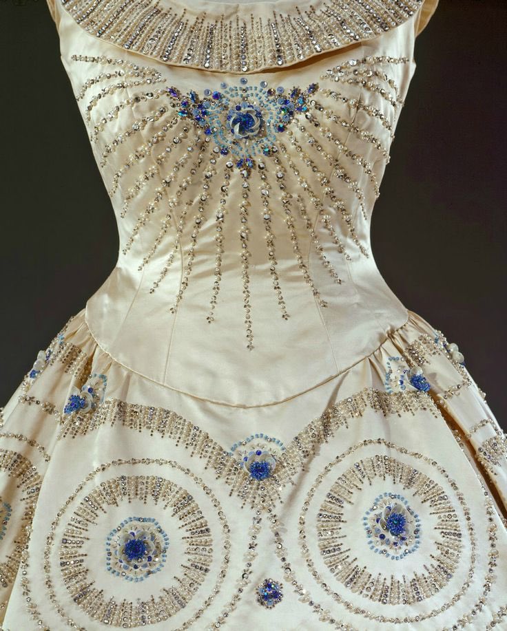 kateStrasdin's tweet photo. Listening to a lovely interview with Maureen Markham, one of the embroiderers who worked on this 1957 Hartnell gown worn by the Queen on a visit to America. She describes sitting under the window four aside along a table to bead the circles. Stories of these hands are fab @RCT https://t.co/igy3H585Yq