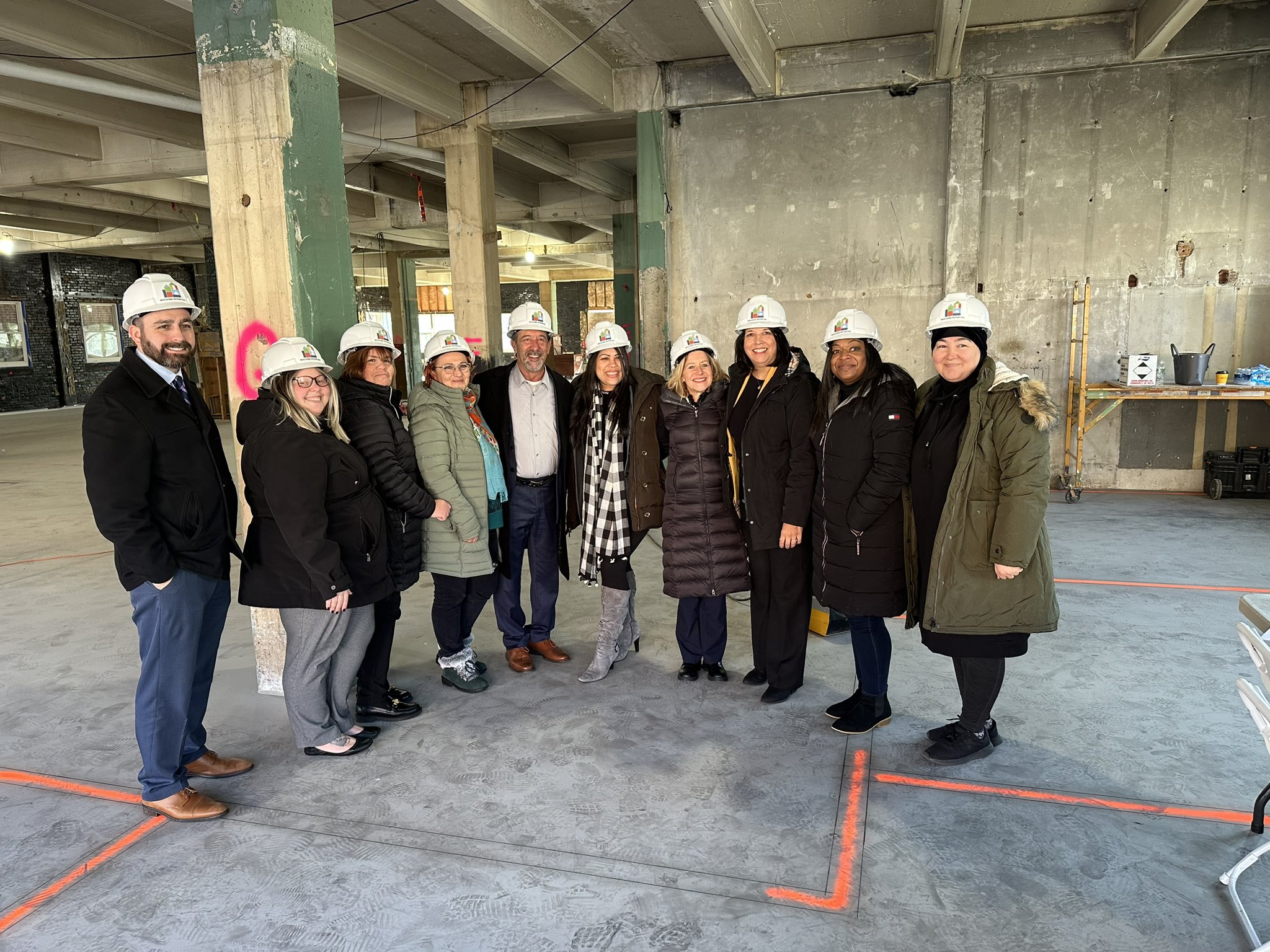 Group photo of people inside building under construction.