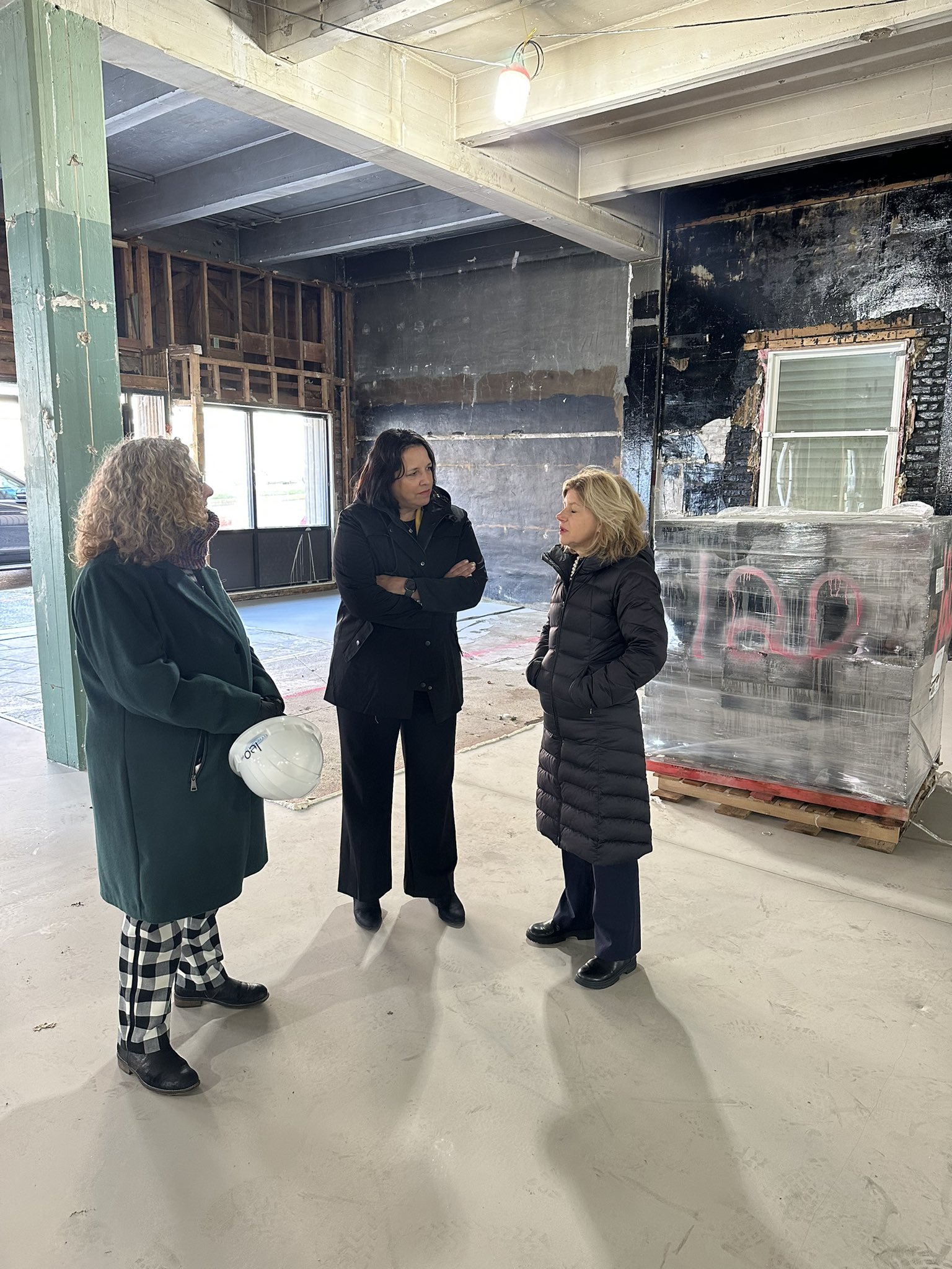 LG Driscoll speaking to people inside building under construction.