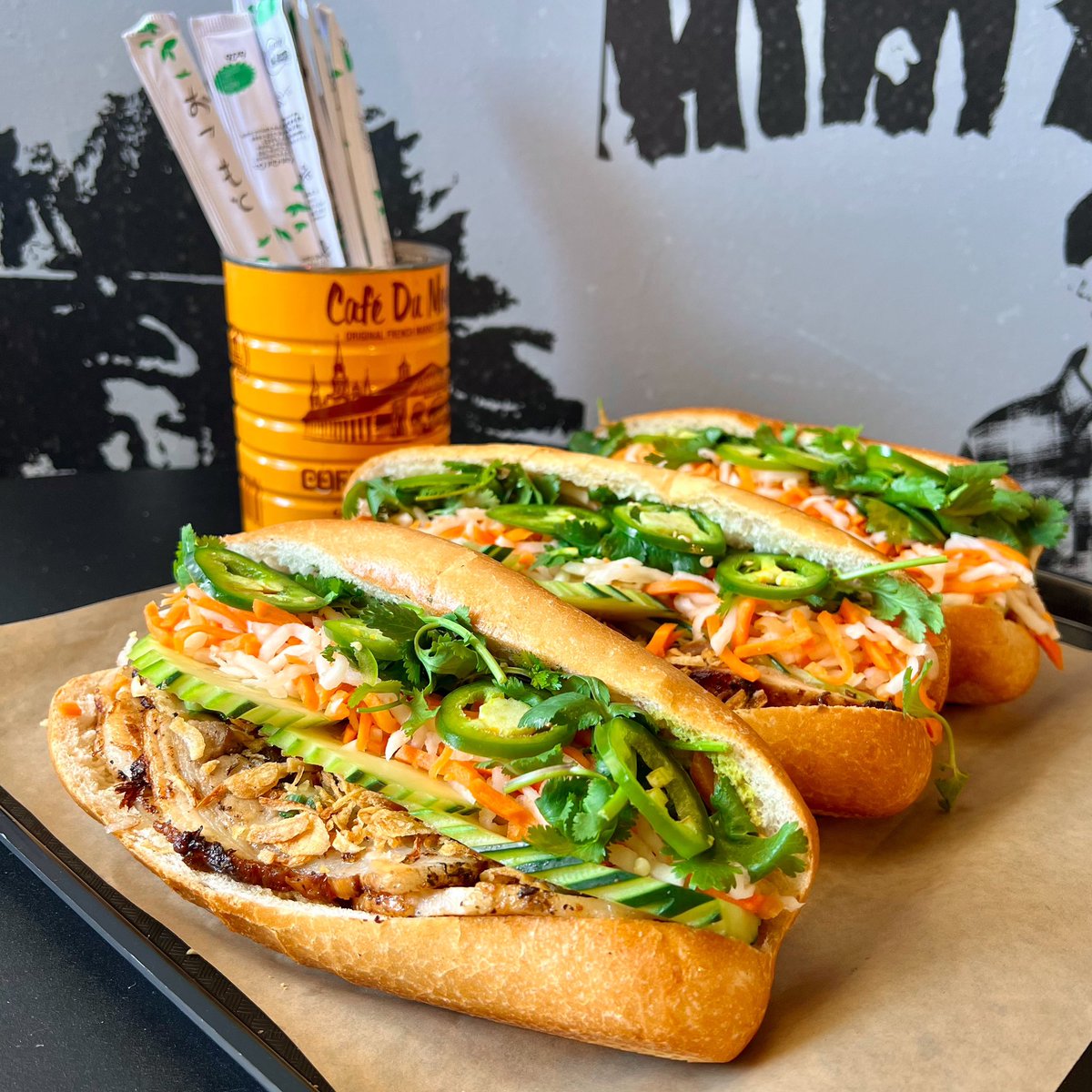 A whole lot of flavor lined up for you at MBM! From front to back is our Porchetta, BBQ Lemongrass Chicken, and Shredded Chicken Bánh Mì 😋 Order yours online from today through Saturday from 10:30 AM to 2 PM