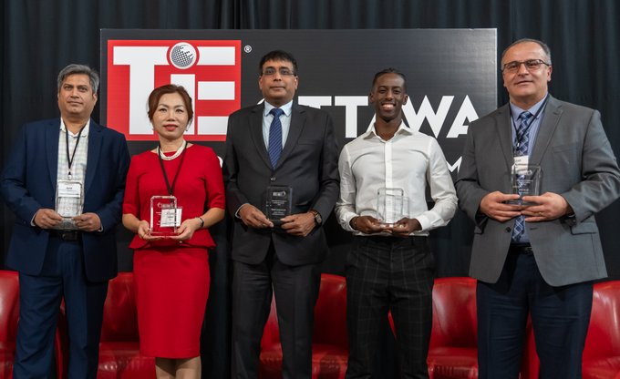 Five individuals holding Immigrant Entrepreneur Awards