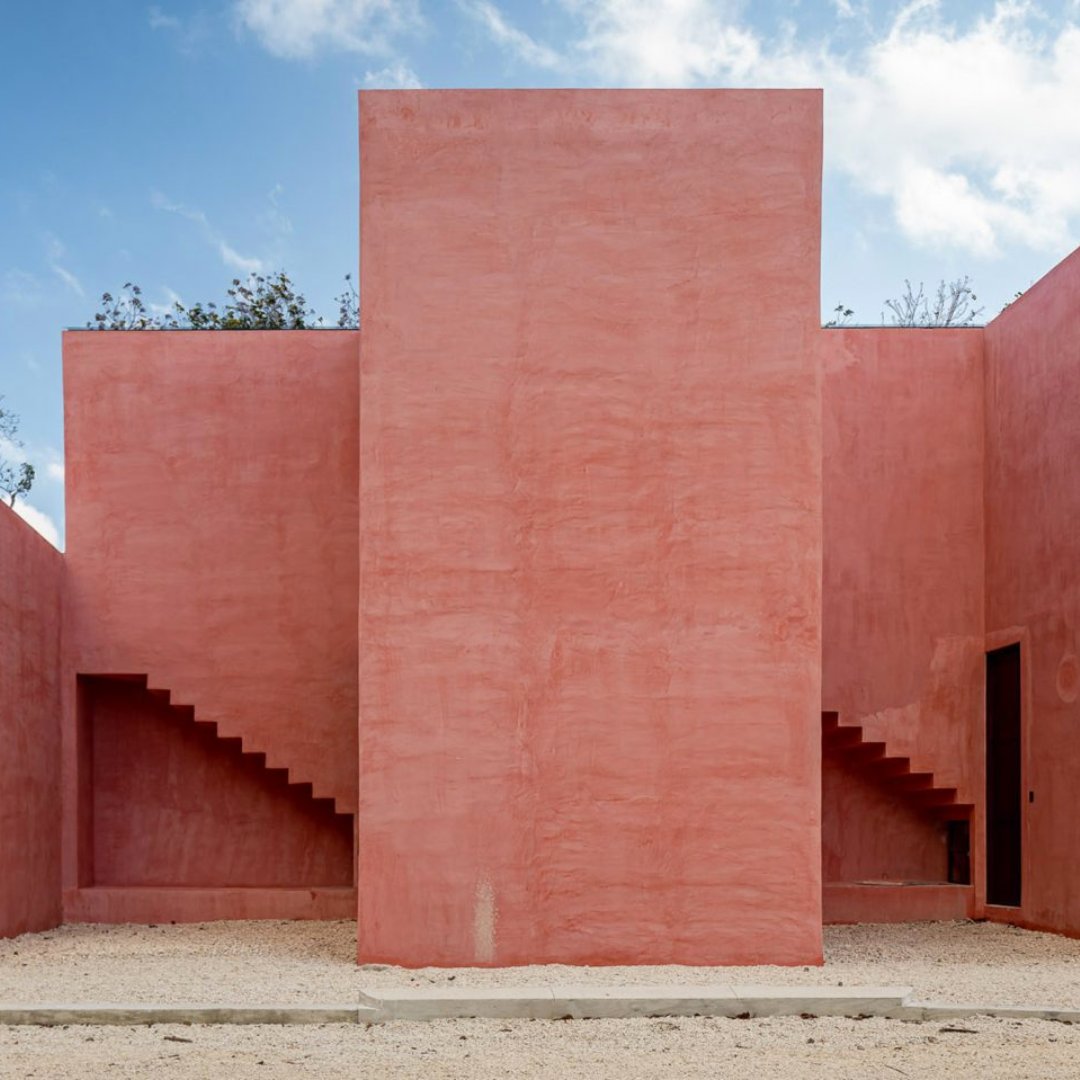 Architecture firm Coyote Arquitectura have unveiled a pink housing complex with residential units that repeat and interlock in Tulum, Mexico. The development consists of nearly 40 homes arranged in two parallel lines separated by a long, landscaped axial alley. #PinkFriday