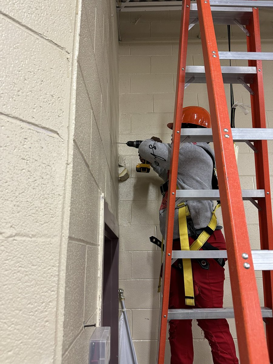 MHSIndMain's tweet image. Using what we learned in class to hang another sponsor banner in the shop. Proper PPE doning; hard hats, safety harness and lanyards used, all while practicing proper ladder safety and procedures. @MinorHighTigers @JEFCOCareerTech @SkillsUSA