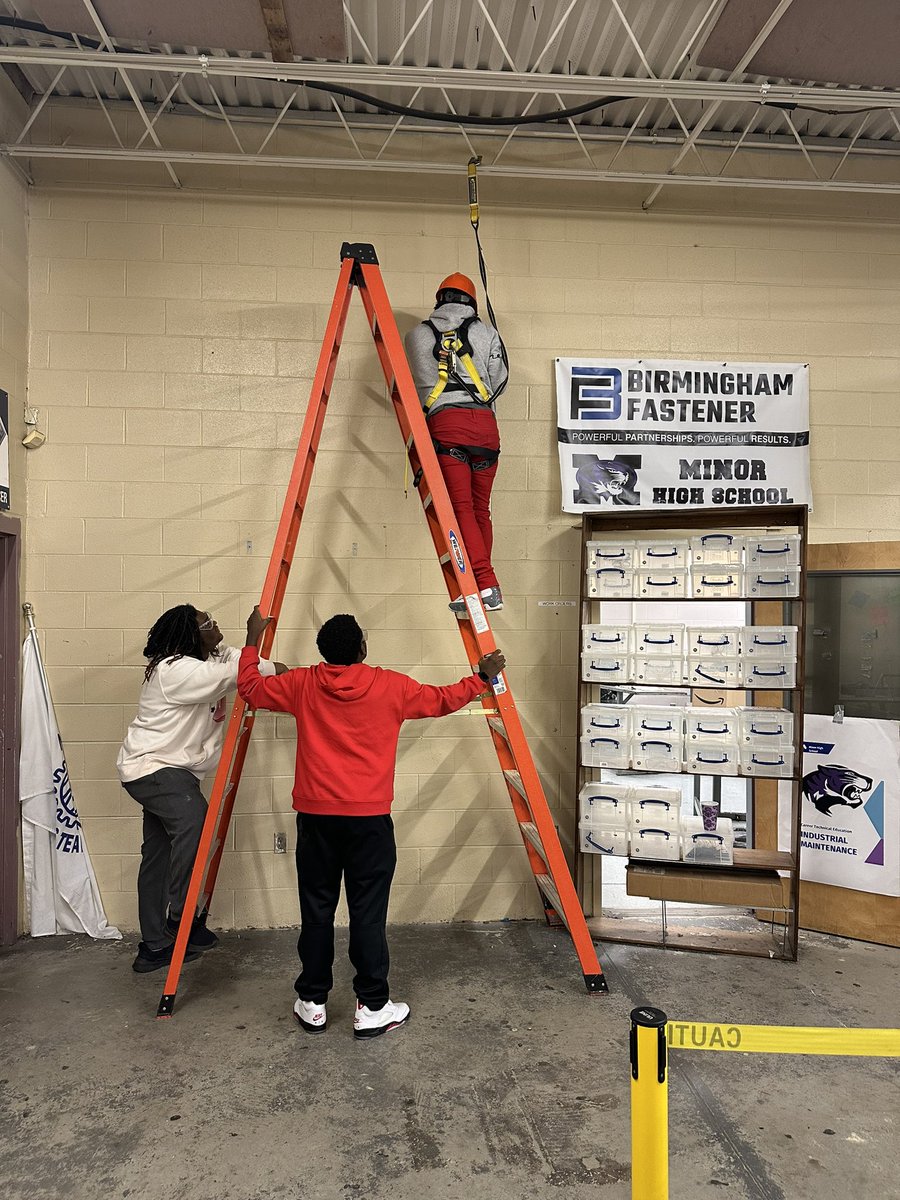 MHSIndMain's tweet image. Using what we learned in class to hang another sponsor banner in the shop. Proper PPE doning; hard hats, safety harness and lanyards used, all while practicing proper ladder safety and procedures. @MinorHighTigers @JEFCOCareerTech @SkillsUSA