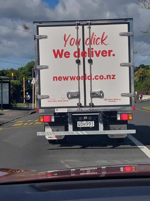 "You dick. We deliver" on the back of a New World truck