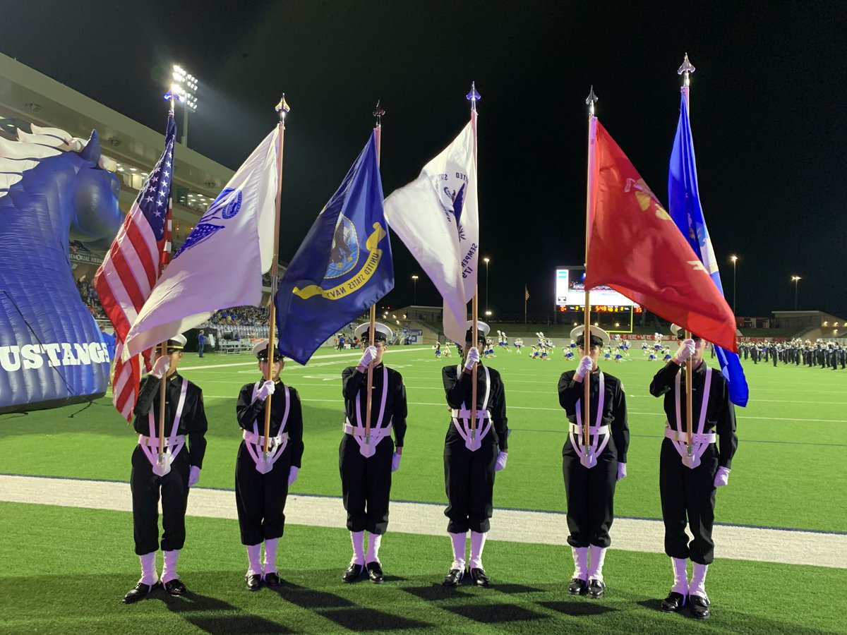 Halftime at the Veterans Appreciation Game and NJROTC leads the veterans in the end zone to be recognized; lead by their service flag.