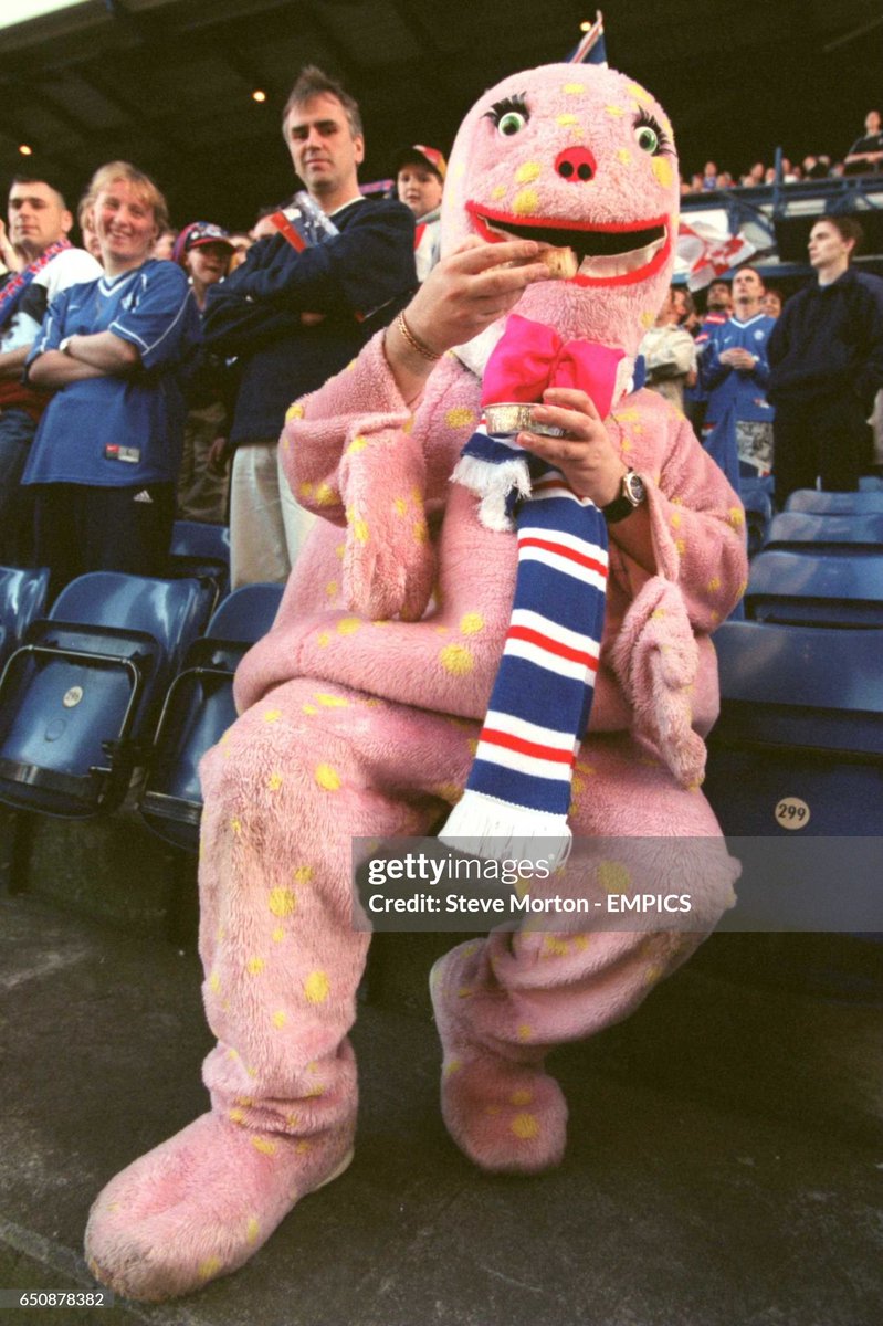 A man dressed as Mr Blobby eats a pie during the Bank Of Scotland Premier League match between Rangers and Dundee (2000)