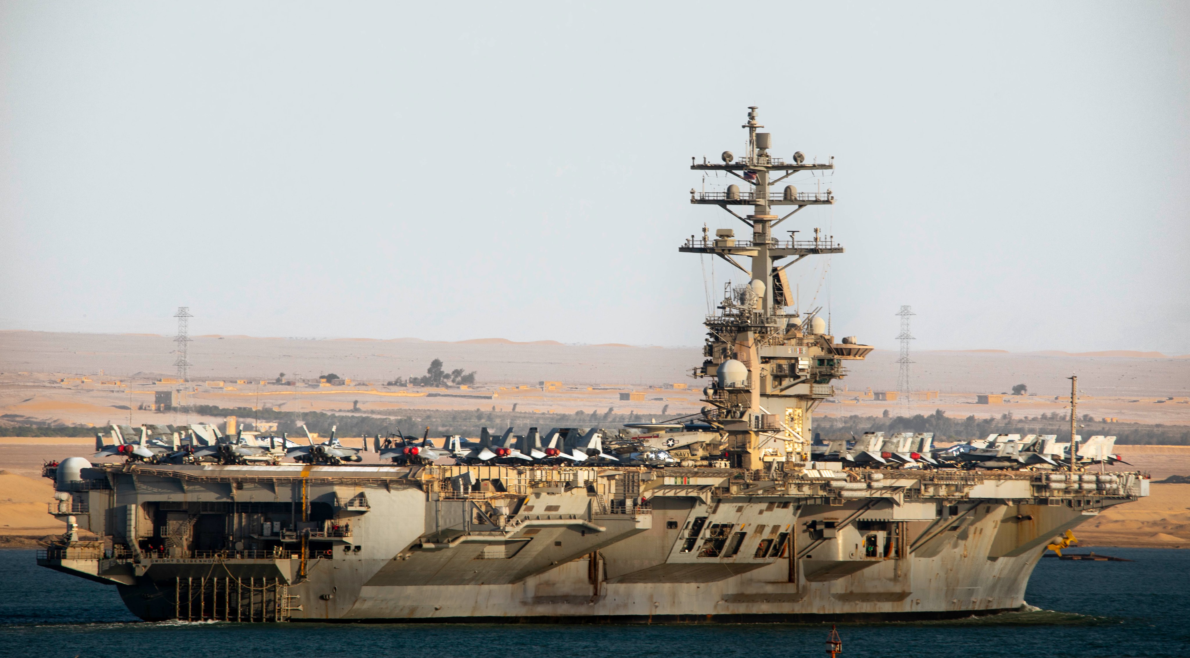 Het nucleair aangedreven vliegdekschip USS Dwight D. Eisenhower (CVN 69) van de Nimitz-klasse passeert het Suezkanaal, 1 november. 4. Dwight D. Eisenhower (IKE) is het vlaggenschip van de Dwight D. Eisenhower Carrier Strike Group (IKECSG), een geïntegreerd gevechtswapensysteem dat klaar staat om te reageren op een reeks onvoorziene gebeurtenissen ter ondersteuning van de nationale veiligheidsprioriteiten. IKECSG wordt ingezet in het operatiegebied van de Amerikaanse 5e Vloot om de maritieme veiligheid en stabiliteit in het Midden-Oosten te helpen garanderen. (Foto van de Amerikaanse marine door massacommunicatiespecialist 2e klas Keith Nowak)