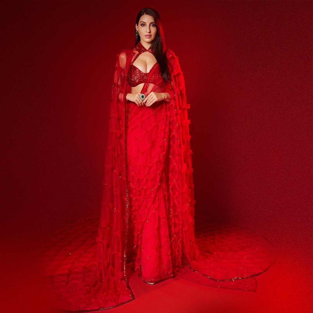 Where red reigns, couture follows – our enchanting cape, the monarch of fashion's finest drapes #NoraFatehi in its breathtaking embrace. Paired with @ManishMalhotra Zambian Emerald and Diamond High Jewellery #ManishMalhotra #JioWorldPlaza