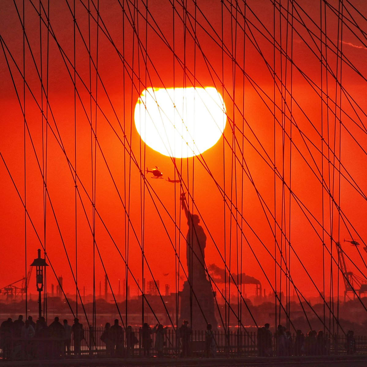 The sun sets behind the Brooklyn Bridge and Statue of Liberty in New York City, Sunday evening #newyork #newyorkcity #nyc #brooklynbridge #statueofliberty #sunset