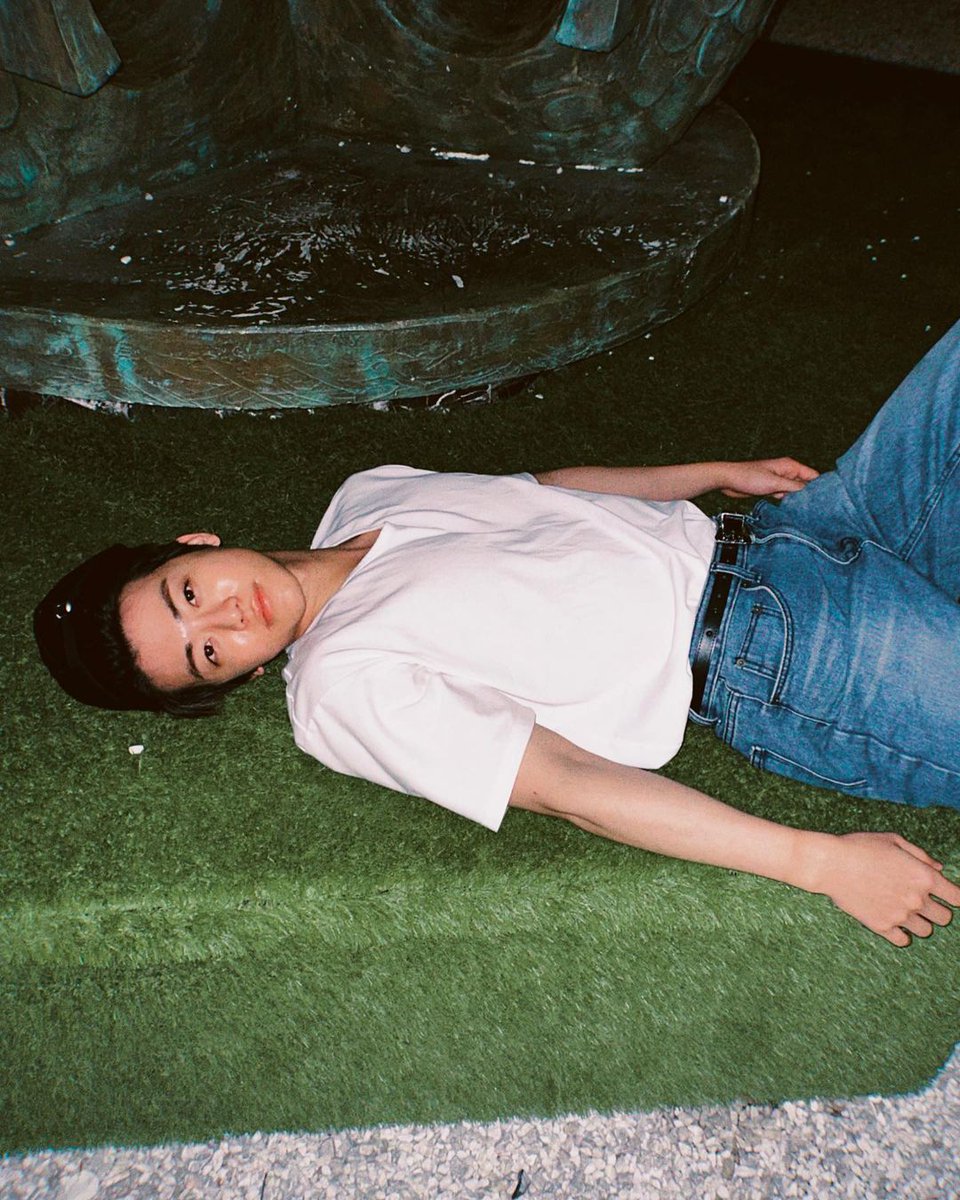 Seizing the moment, this man reclined gracefully, exuding a model's allure, the brim of his hat adding a touch of mystique to the tranquil streets of Paris.