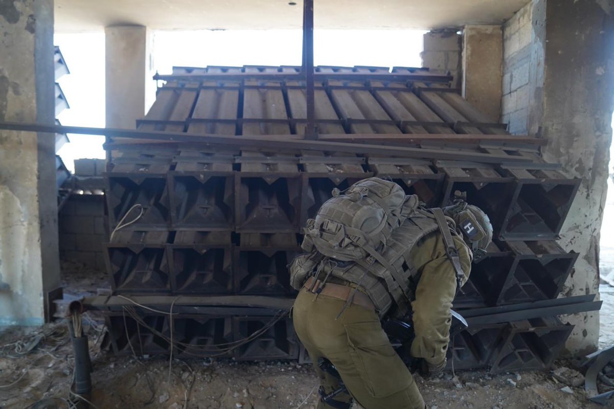 manniefabian's tweet photo. Israeli forces operating in the northern Gaza Strip have located several rocket launchers and some 50 rockets, located in a compound used by a youth movement and a mosque, the military says.

The IDF publishes a video of the commander of the Nahal Brigade’s 50th Battalion, Lt. Col. Tomer Sayag, showing dozens of rocket launchers his forces found inside a building used by the Palestinian Scout Association.

Sayag says the empty rocket launchers were aimed at Ashkelon or central Israeli cities. Outside, some 50 rockets — bearing the logo of the Palestinian Islamic Jihad — were found in an underground storage site.

Separately, the IDF releases a video of the 460th Armored Brigade locating a number of empty underground rocket launchers adjacent to a mosque in northern Gaza. The video shows the launchers’ electrical wiring running inside the mosque, from which they are activated.