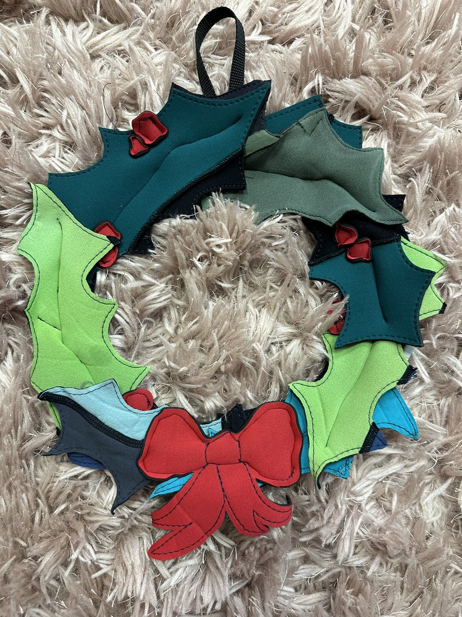 FlotsamFlo's tweet photo. HOW AMAZING is this eco Christmas wreath? With greens from broken wetsuits, the zip pull as the loop and board leash stitched inside the wreath to make it rigid. All of this can’t easily be recycled🎄❤️✨ #wetsuit #wetsuitupcycle #christmas #christmasdecoration #holly #flotsamflo https://t.co/MpY4As3jpi
