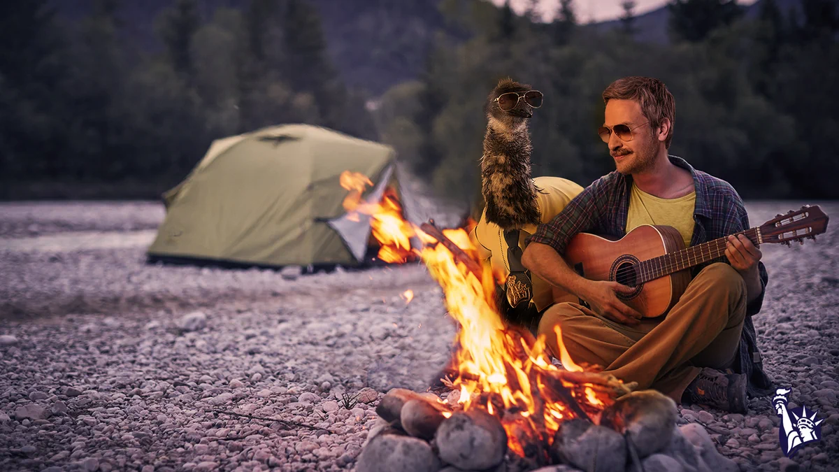 LiMu Emu & Doug are camping on the beach. There is a tent in the background as they sit close to a campfire and Doug strums a guitar.
