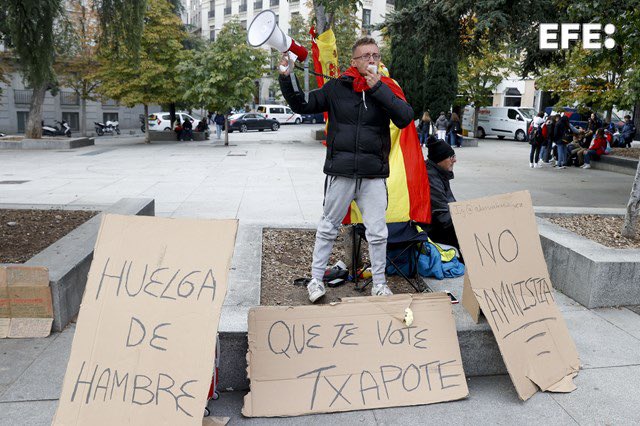 wallstwolverine's tweet photo. Un hombre de 28 años se encadena a un árbol en la plaza de las Cortes, frente al Congreso, donde ha iniciado una huelga de hambre en contra de la amnistía. https://t.co/8uvBQ2iEi6