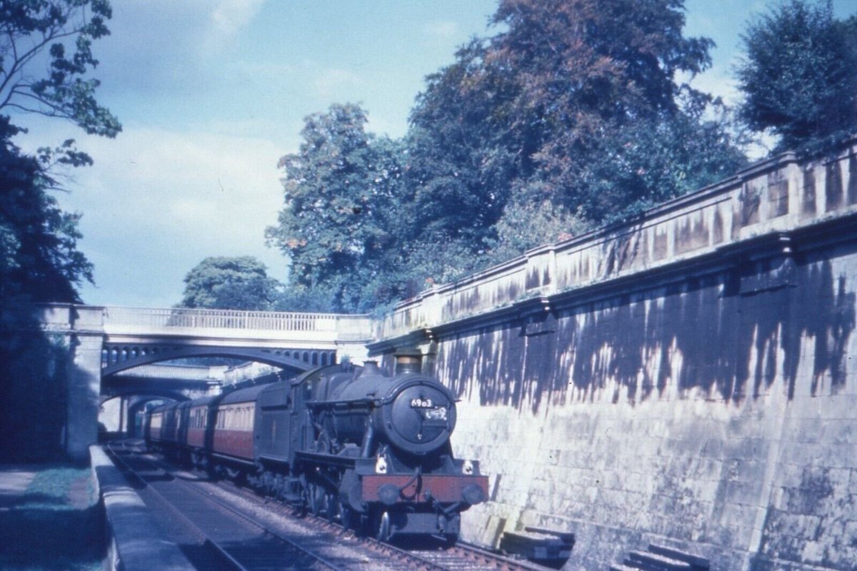 Passing under the iconic balustrade walls of Bath Sydney Gardens, 6959 6983 Otterington Hall is shot by Pursey C. Short on a Down Extra consisting of Blood & Custard GWR stock in September 1952. 6983 would be withdrawn 25 August 1965 from 81F Oxford Shed after 17 years' service.