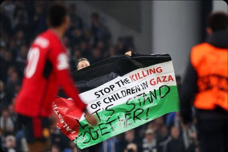 أوقفوا قتل الأطفال في غزة، دعونا نتحد سويًا  هذا ما كتبه مشجع اقتحم ملعب المباراة في دوري أبطال أوروبا أمام الجميع في مباراة مانشستر يونايتد وهو يرفع علم فلسطين