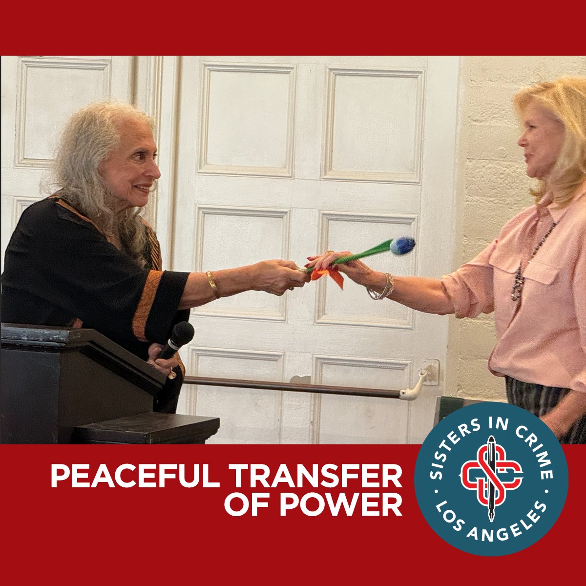 Peaceful Transfer of Power: Paula Bernstein passes the gavel (or, in this case, a florally enhanced pen) to Nancy Cole Silverman at the November 2023 SinCLA chapter meeting, officially installing a new president for Sisters in Crime Los Angeles.