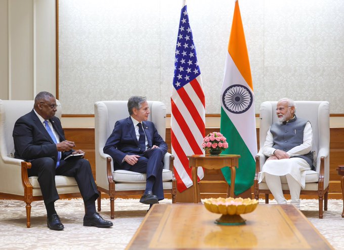 Secretary Blinken sits down for a meeting with Indian Prime Minister Narendra Modi. Defense Secretary Austin sits to his left, U.S. and India flags are centered.