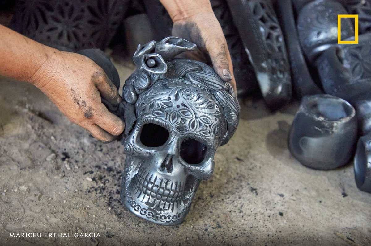 A potter extracts a recently fired clay skull from the kiln in Oaxaca, Mexico.