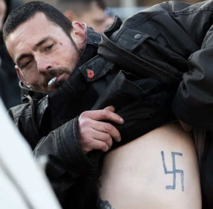 Wearing a Poppy with a Swastika tattoo.

No comment.