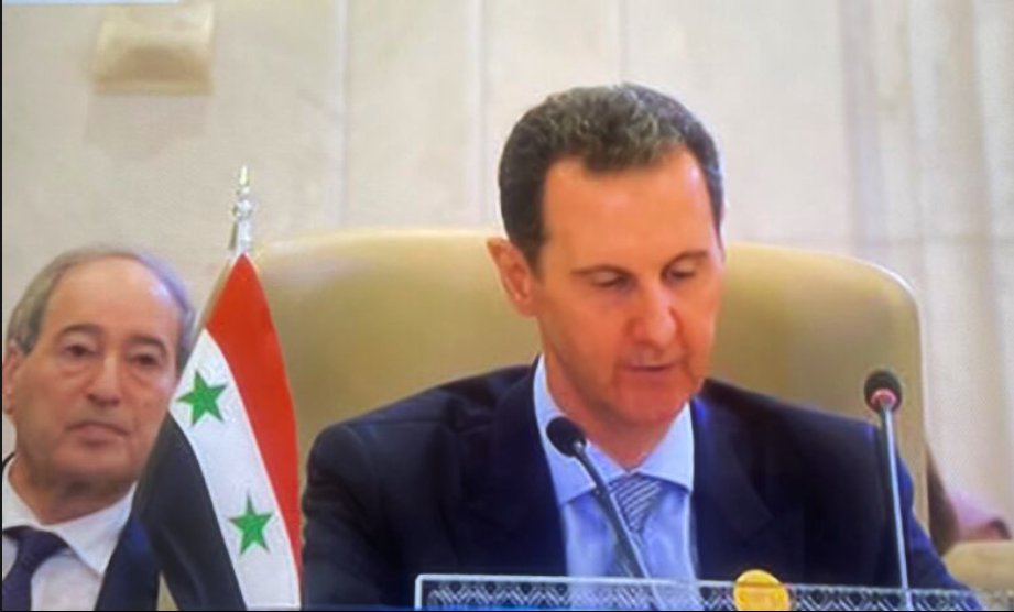 IbrahimAlAssil's tweet photo. Assad addressing the Arab-Islamic Summit on Gaza. Assad killed over 500,000 people, gased children using chemical weapons, displaced over 12,000,000 people, killed tens of thousands of people under torture, around 100,000 of the people he arrested are still forcibly disappeared, including around 10,000 women and children. The second pic is from the Palestinian Yarmouk Camp in Syria after Assad's air forces destroyed it.