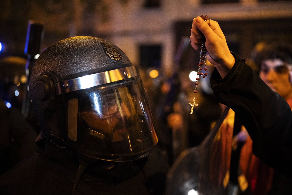 A demonstrator holds a rosary next to a police officer during a protest against the amnesty at the headquarters of Socialist party in Madrid, Spain, Saturday, Nov. 11, 2023. <a href="/AP/">The Associated Press</a> photo/Joan Mateu Parra