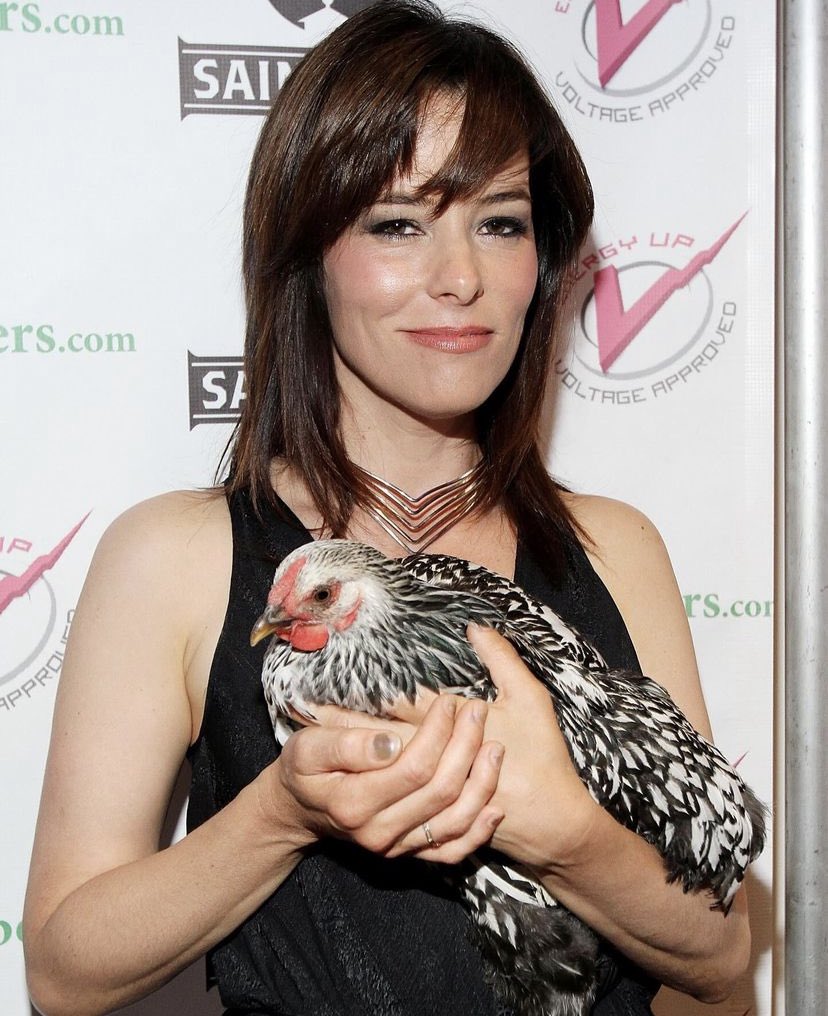 Parker Posey holding a chicken