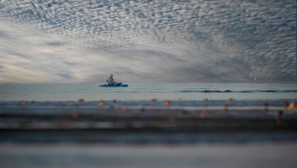 A lone kayaker braving the ominous ocean's vastness. The morning was still and soft waves rolled upon the shore. He paddled on, a beacon of resilience and the day’s adventure. Sometimes the greatest courage is found in solitude. #KayakAdventures #OceanMystery #beachlife #beach