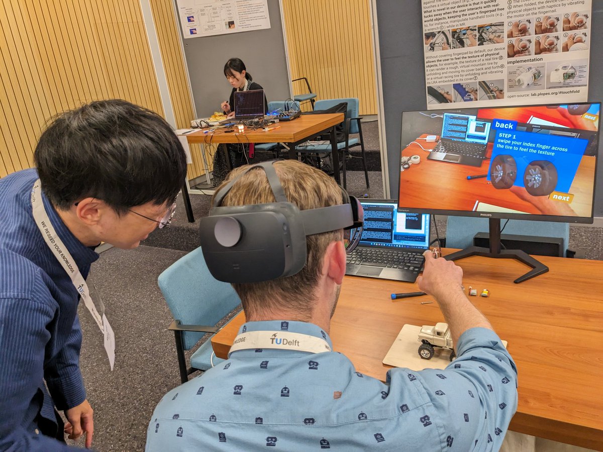 @tengshanyuan is demo'ing Touch & Fold at the senaatsaal at #worldhaptics2023 come and try it. This allows your finger to feel pressure and textures in mixed reality and yet, have tou finger pad free to hold tools and manipulate objects! (Paper from CHI 21, and totally new demo!)