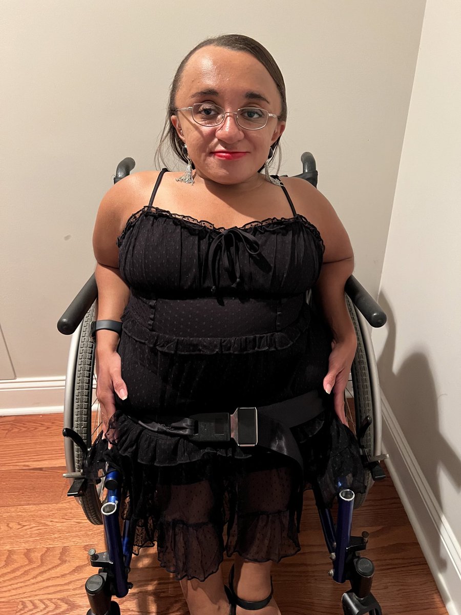 Vilissa is wearing a black lacy dress with a red lip