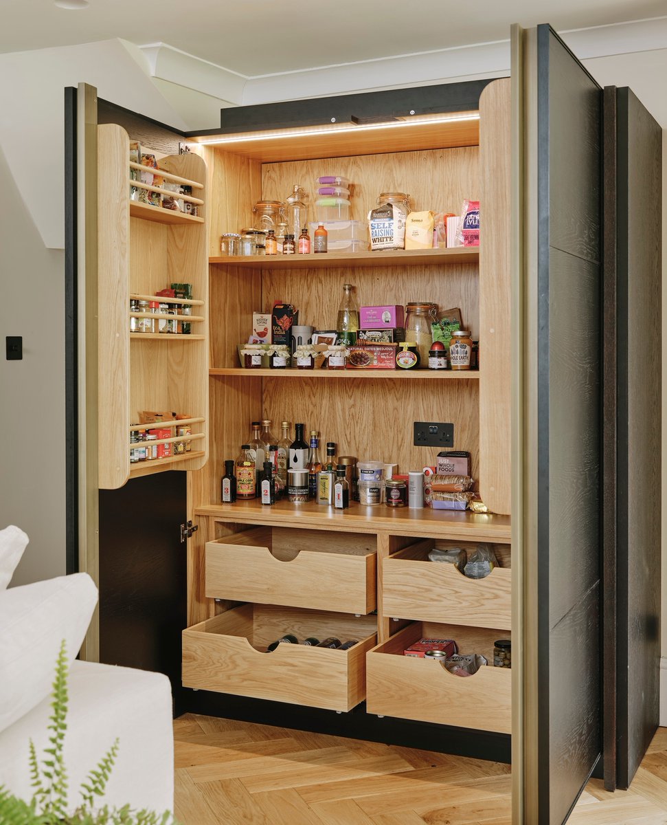 This large larder cupboard in The Hackney Kitchen is placed strategically by the entrance to the kitchen for heavy bags as you enter from the hallway, incorporating racks for spices and condiments with drawers below. #LedburyStudio #CopperKitchen