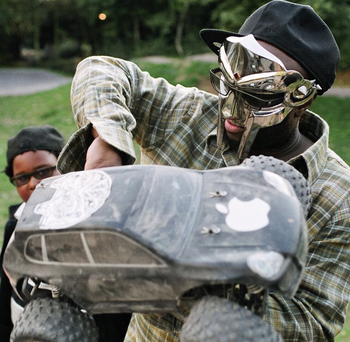 Grantpa23's tweet photo. MF DOOM photographed in Haggerston Park in 2012 w/ his son King Malachi 

📷: Alex De Mora https://t.co/m2zsA0N3Y6