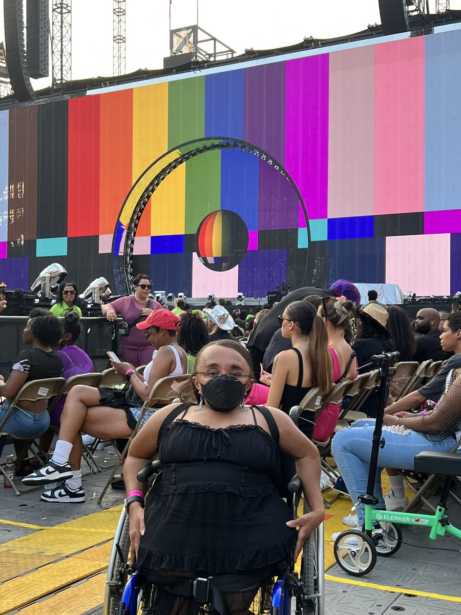 Vilissa is posing for a picture in front of the rainbow pride screen