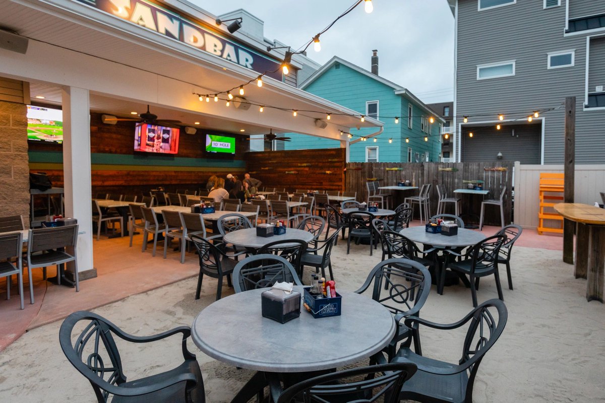 🌴 Enjoy a delicious meal with friends and family at our Sandbar &amp; Grill. Our outdoor space is the perfect spot to savor fresh food, soak up the ocean breeze. #OceanDriveNJ #SandbarAndGrill #OutdoorDining