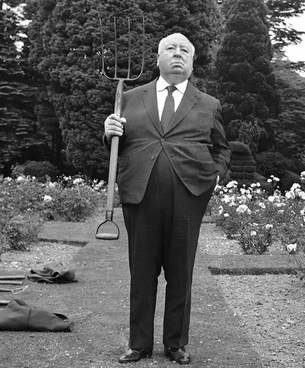 historyinmemes's tweet photo. The photograph capturing Alfred Hitchcock holding a pitchfork on the lawns of Pinewood Studios in Buckinghamshire, United Kingdom, on July 22, 1971, provides a glimpse into the life and career of the legendary film director, producer, and screenwriter. 

Alfred Hitchcock, born on August 13, 1899, in Leytonstone, Essex, England, is widely regarded as one of the greatest filmmakers in the history of cinema. Known for his distinctive style and innovative storytelling techniques, Hitchcock's contributions to the suspense and thriller genres have left an indelible mark on film.

By 1971, Hitchcock was already a highly celebrated director, having directed numerous iconic films throughout his career. Some of his most renowned works include "Psycho" (1960), "Vertigo" (1958), "North by Northwest" (1959), and "Rear Window" (1954), among many others. His films often featured themes of suspense, psychological tension, and dark humor, showcasing his mastery of building suspense and creating unforgettable cinematic experiences.

Pinewood Studios, where the photograph was taken, is a major film and television production studio located in Buckinghamshire, England. Established in 1935, Pinewood Studios has been the backdrop for countless films, including many of Hitchcock's productions. The studio has a rich history and continues to be a prominent hub for the British and international film industry.

The image of Alfred Hitchcock holding a pitchfork offers a glimpse into his unique personality and the way he blended his public image with his cinematic work. Hitchcock was known for making cameo appearances in his films, and he often made playful and unexpected appearances in public events, which became part of his personal brand. The photograph captured during the filming of "Frenzy" (1972), Hitchcock's penultimate film, showcases his penchant for merging his persona with his art, adding an element of intrigue and playfulness to his public image.