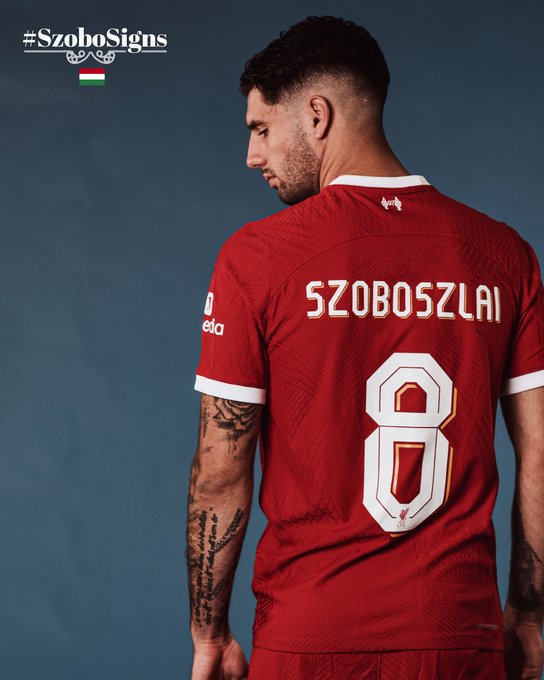 Dominik Szoboszlai showing his name and number during his signing photoshoot, having selected to wear the no.8 shirt for the Reds.
