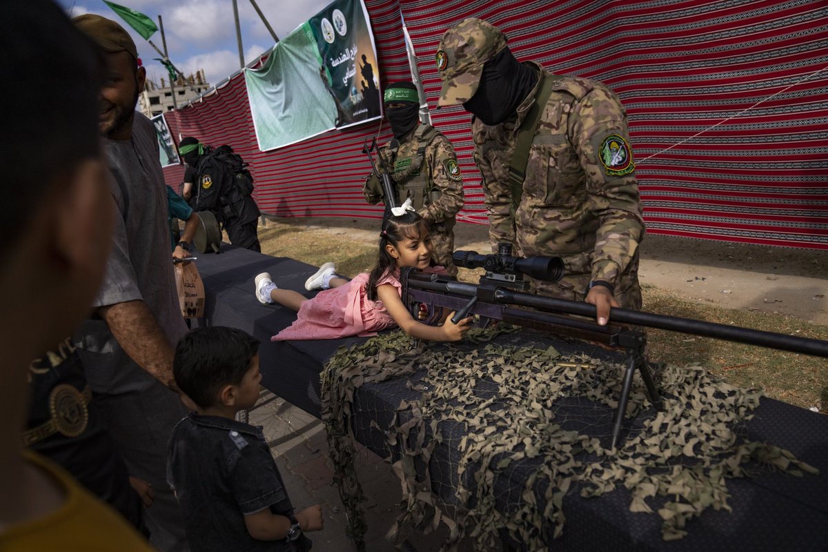 A Palestinian child poses with a weapon at an arms exhibition for the ruling Hamas group's military wing during Eid al-Adha holiday at Nusseirat refugee camp, central Gaza Strip. (AP Photo/Fatima Shbair) @apnews