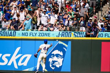 Photo of Julio Rodríguez tossing a baseball to fans sitting in the J-ROD Squad section. 