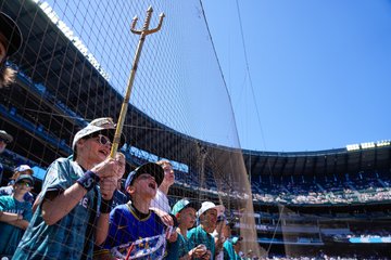 Photo of a young fan holding up a mini-home run trident. 